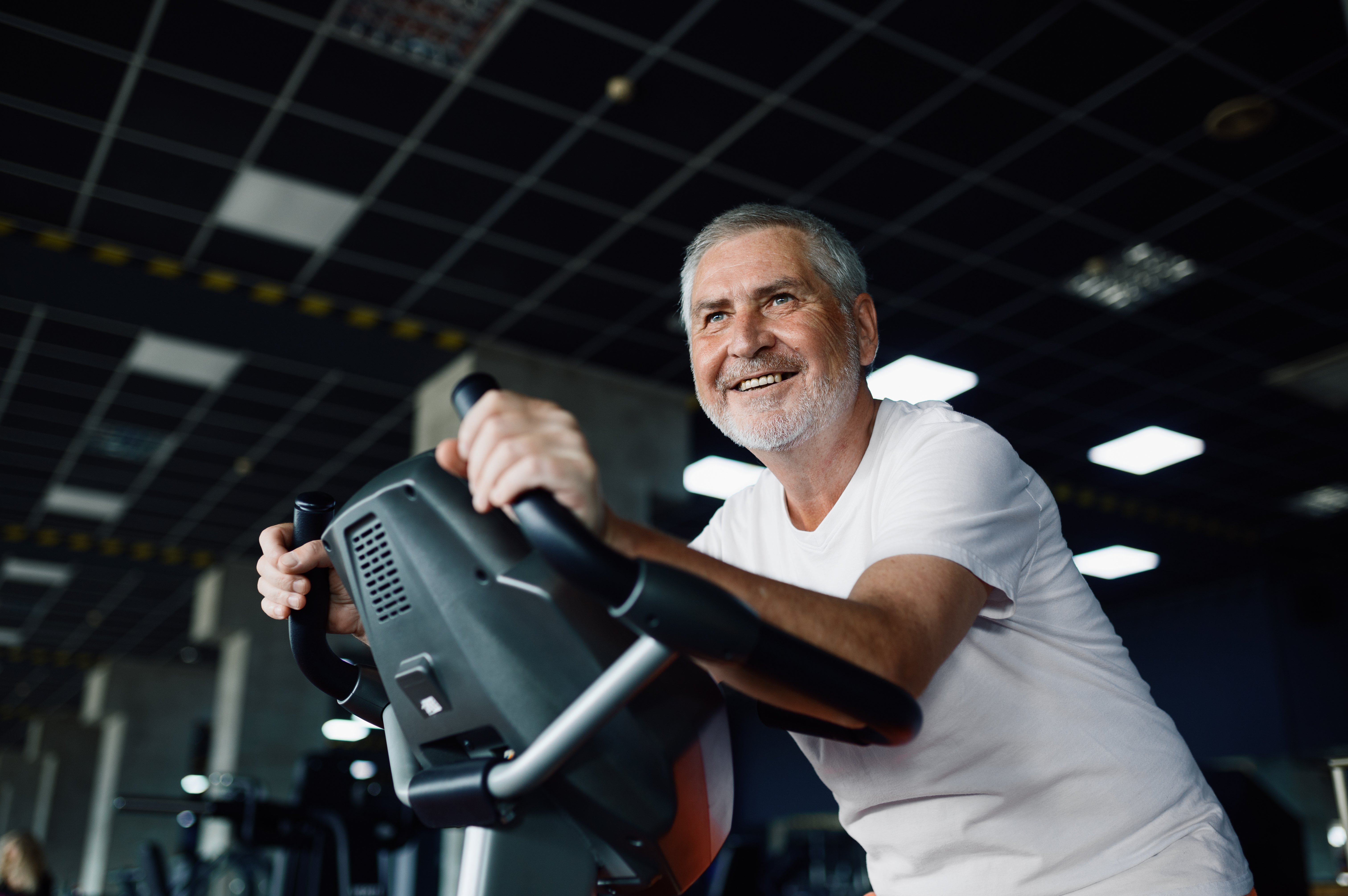 elderly-man-poses-on-exercise-bike-in-gym-2023-11-27-05-08-42-utc