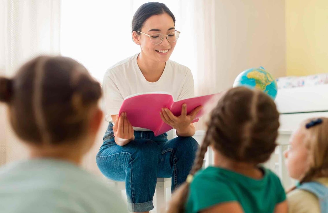 mujer leyendo un libro a unos ninos 